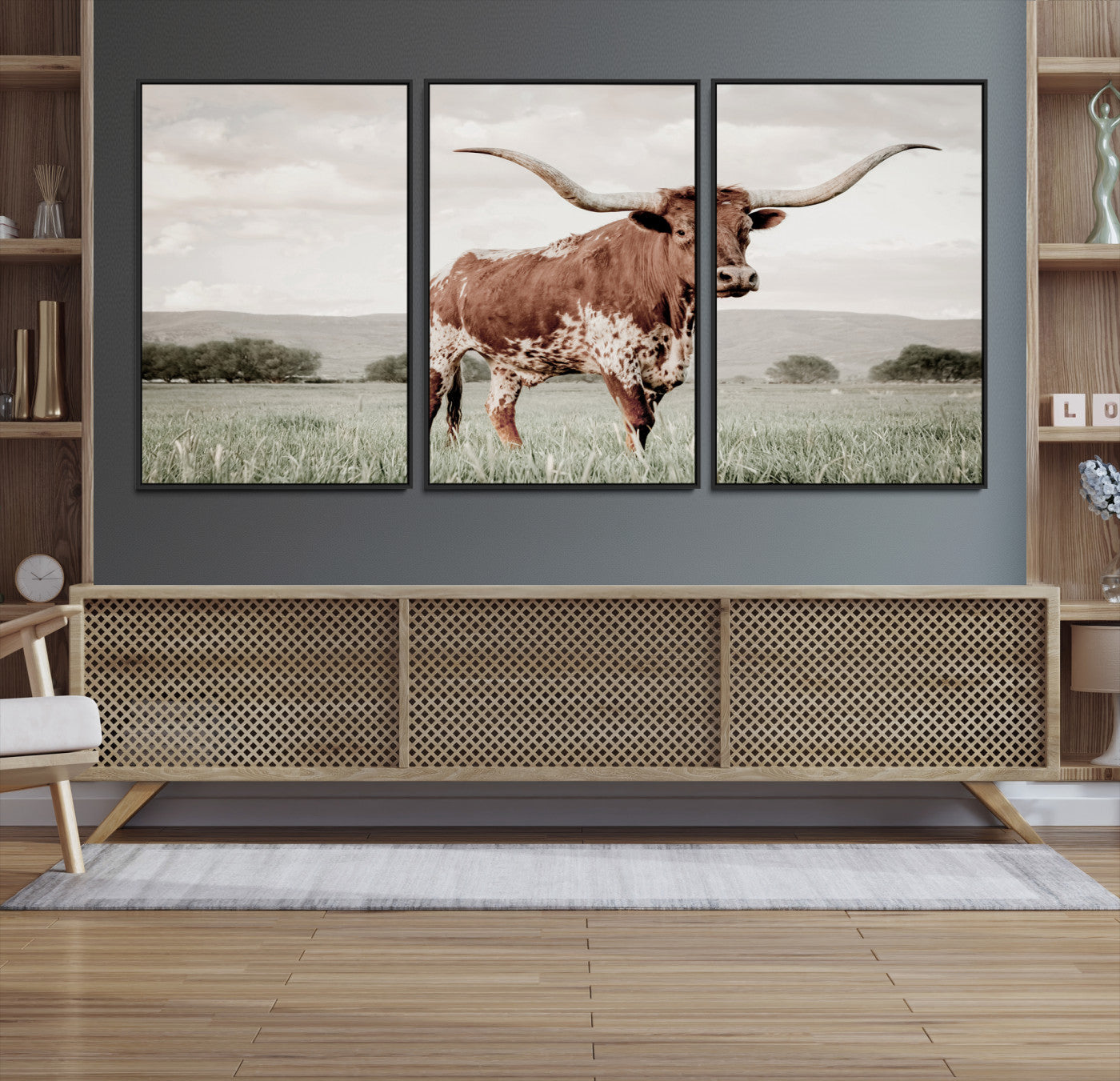 Canvas of a Texas longhorn standing in a grassy field with mountains in the background, ideal for rustic or country-style western wall decor.