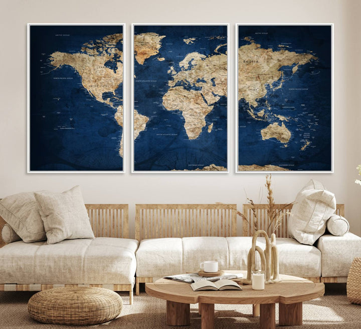 A large framed world map canvas print features beige landmasses set against a grunge-stained deep blue ocean background, creating an intriguing piece of wall art.