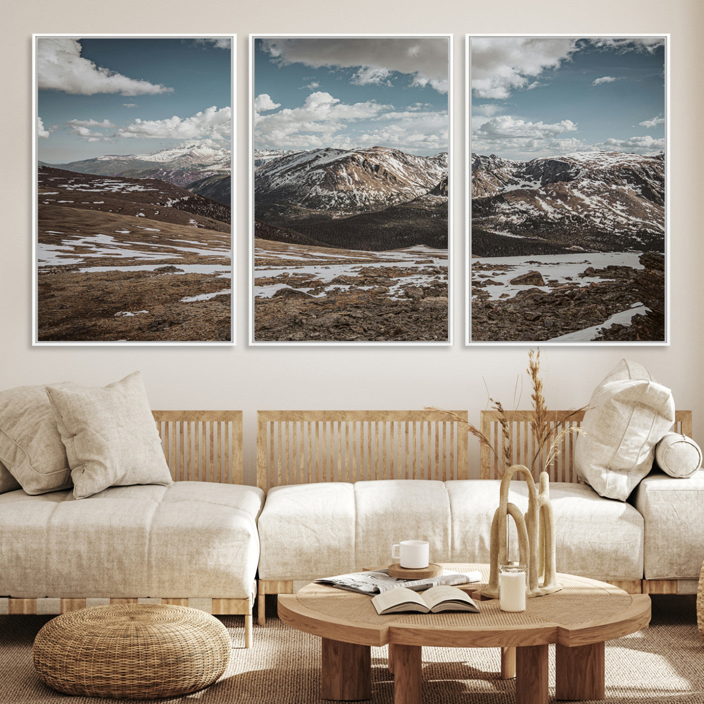 A breathtaking mountain landscape with rugged peaks, patches of snow, and dramatic clouds casting shadows over the vast alpine wilderness.