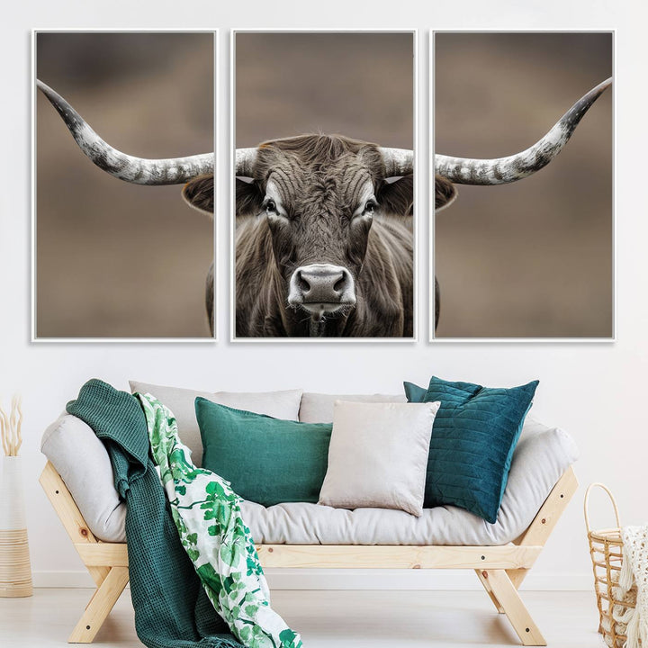 A close-up of a longhorn bull facing forward is featured in the Framed Texas Test-1, set against a blurred brown background.