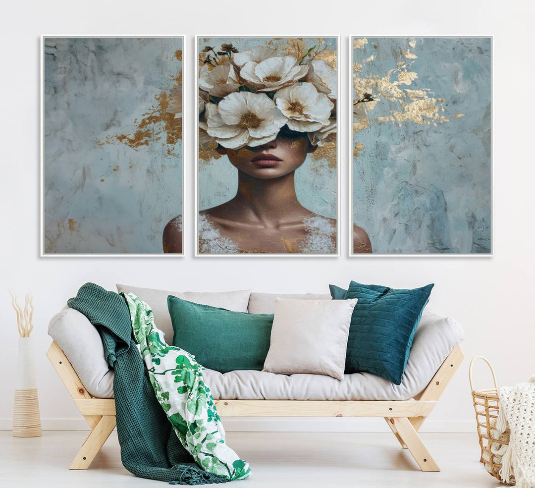 Golden Petal Wall Art: A womans face adorned with a gold floral design on a teal background, presented in a 3-panel modern glam canvas.