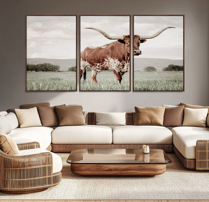 Canvas of a Texas longhorn standing in a grassy field with mountains in the background, ideal for rustic or country-style western wall decor.