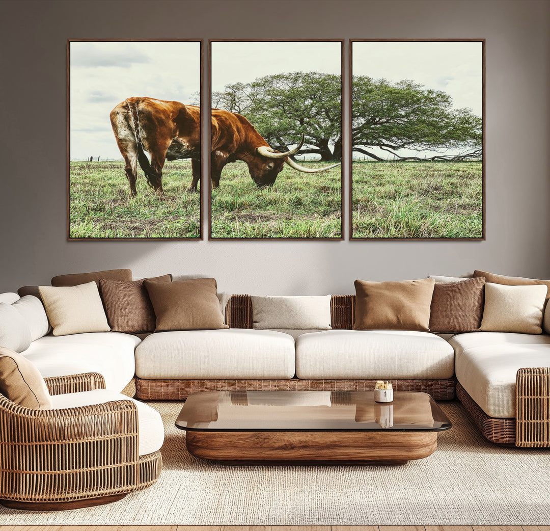 A Texas Longhorn grazing in a green pasture with a large tree in the background, evoking a rustic Western and farmhouse aesthetic.