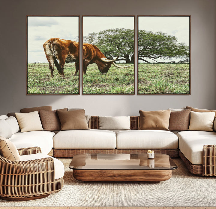 A Texas Longhorn grazing in a green pasture with a large tree in the background, evoking a rustic Western and farmhouse aesthetic.