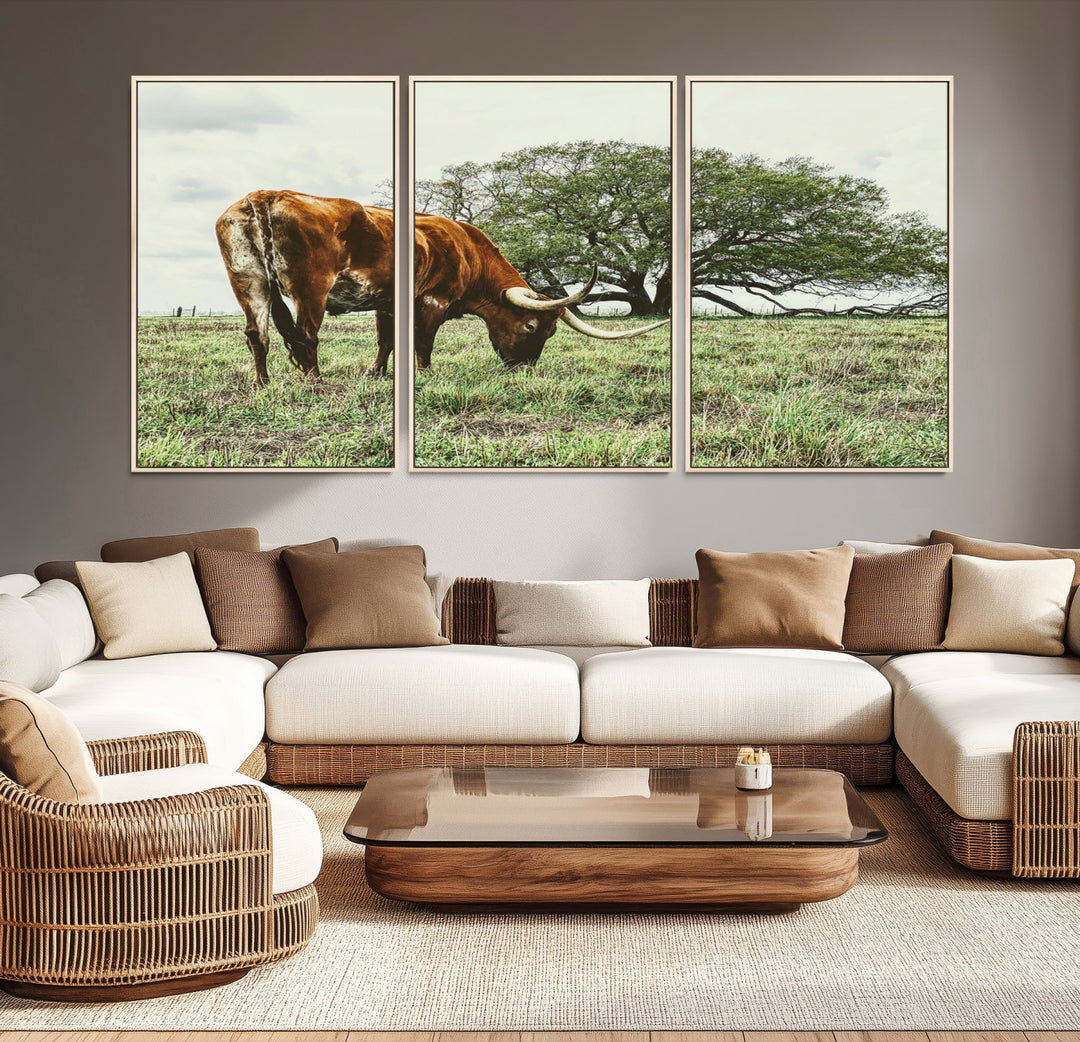 A Texas Longhorn grazing in a green pasture with a large tree in the background, evoking a rustic Western and farmhouse aesthetic.