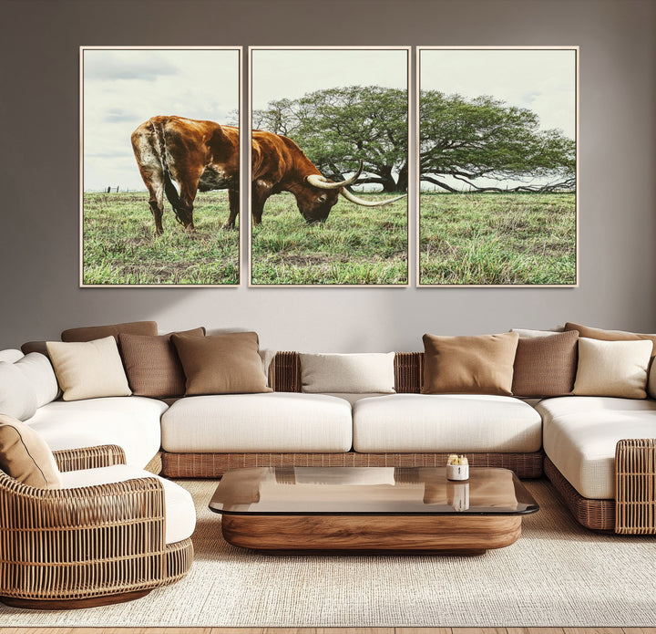 A Texas Longhorn grazing in a green pasture with a large tree in the background, evoking a rustic Western and farmhouse aesthetic.