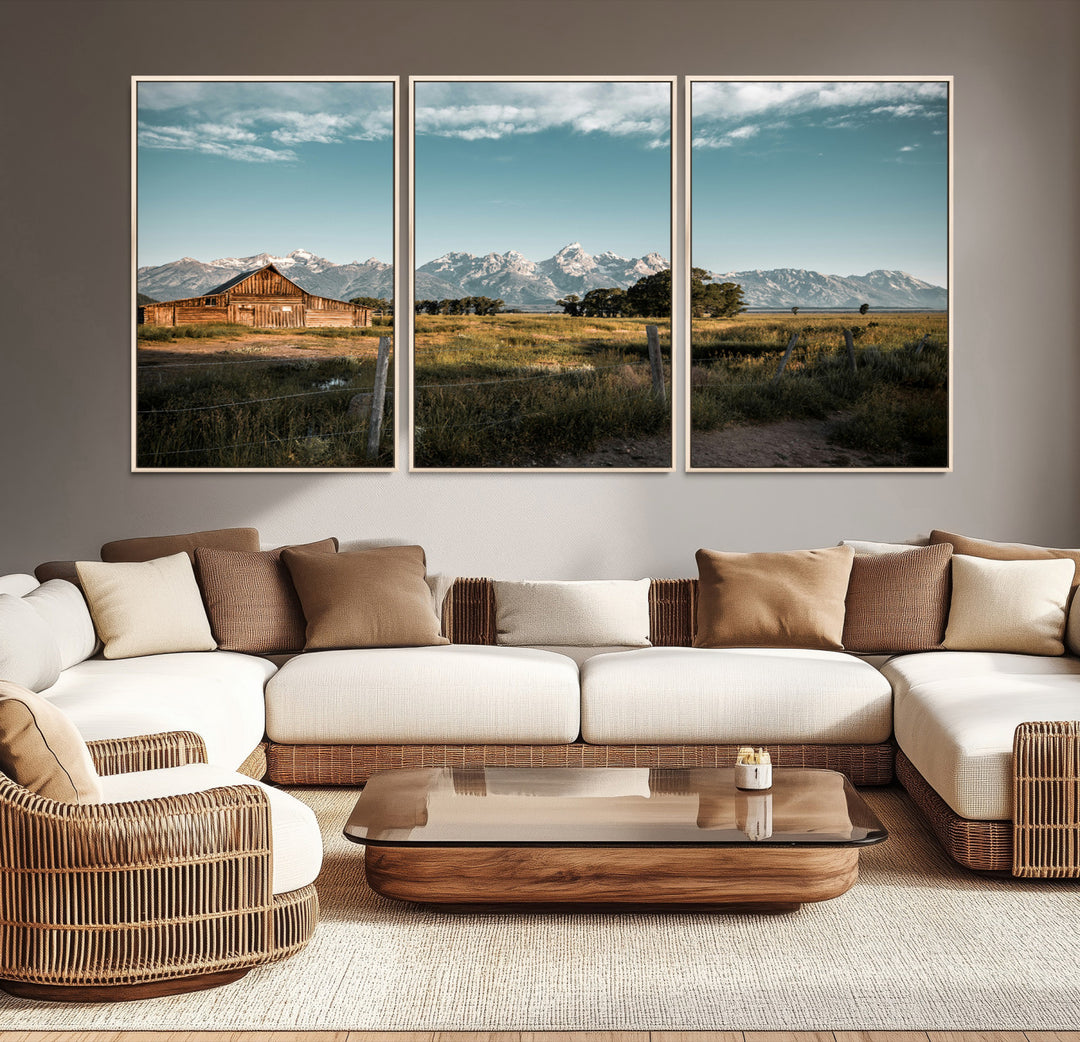 A rustic farmhouse with a wooden barn set against majestic mountain peaks under a soft blue sky, evoking peaceful countryside charm.