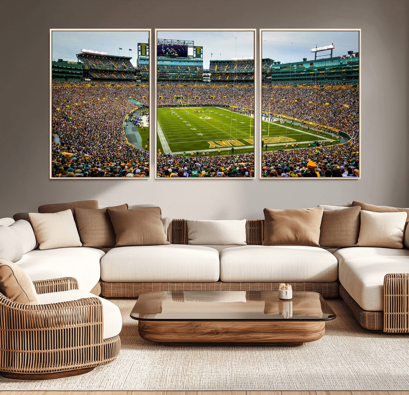 Packed football stadium with thousands of fans watching an American football game on a well-maintained field. The scoreboard displays "Lambeau Field," and players are lined up on the field. The stadium is surrounded by multiple tiers of seating filled wit