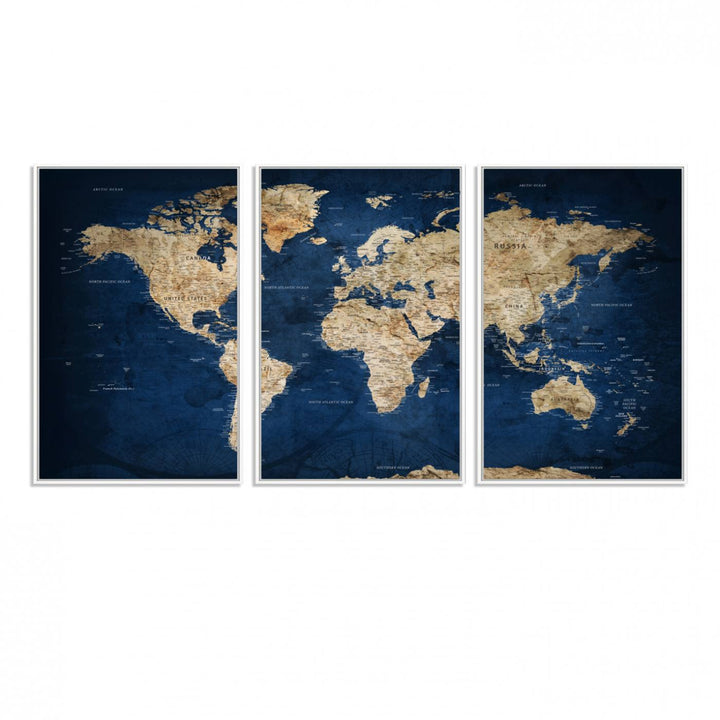 A large framed world map canvas print features beige landmasses set against a grunge-stained deep blue ocean background, creating an intriguing piece of wall art.