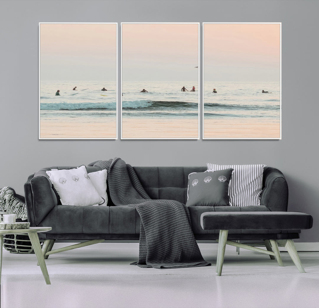Dreamy photo of surfers waiting on soft pastel waves under a pink sunset sky, ideal for soft coastal minimalist or serene ocean-themed home decor.