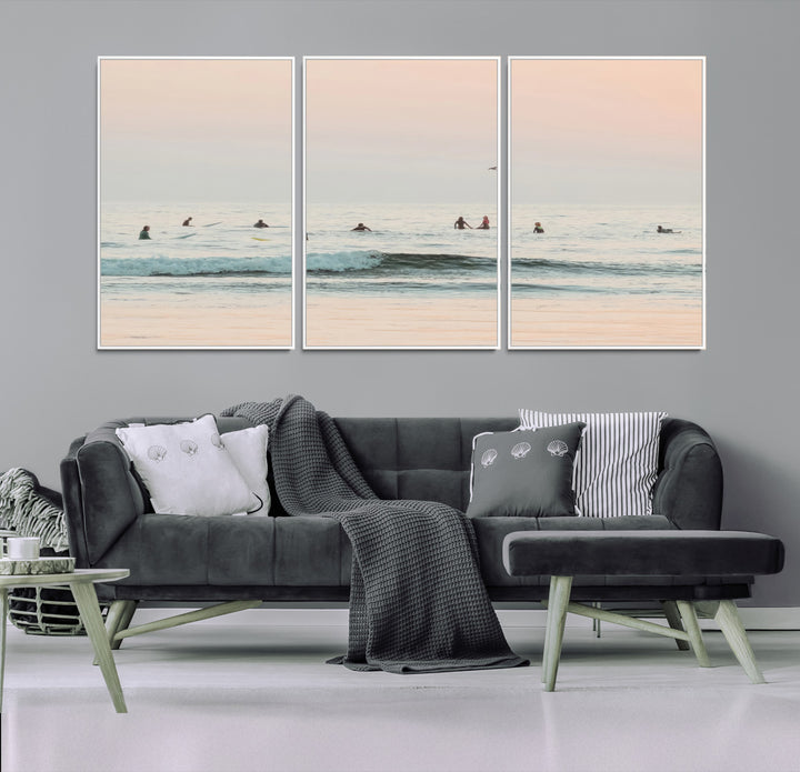 Dreamy photo of surfers waiting on soft pastel waves under a pink sunset sky, ideal for soft coastal minimalist or serene ocean-themed home decor.