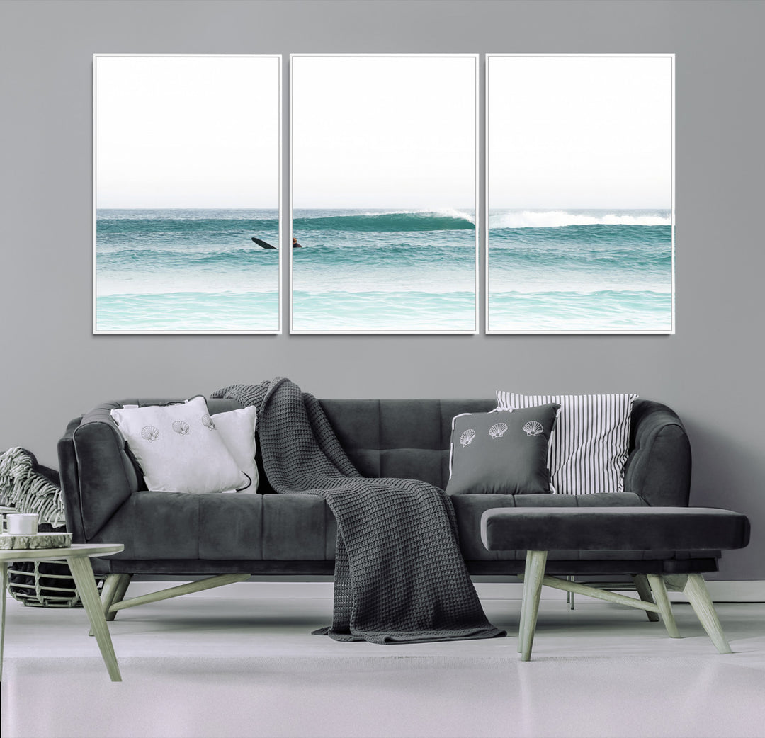Minimalist photo of a lone surfer on calm aqua waves under bright sky, perfect for Scandinavian coastal or serene ocean-inspired home decor.