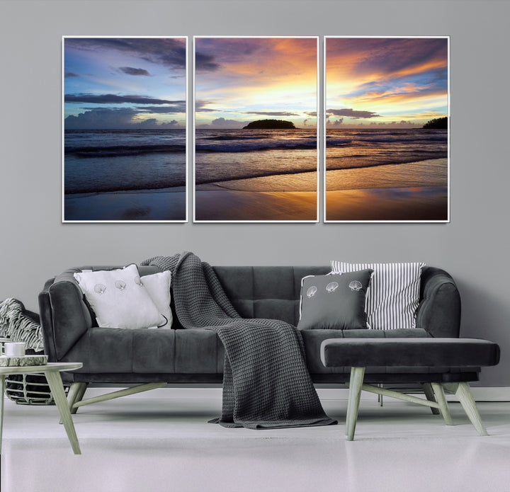 A tropical beach at sunset with waves gently washing ashore, reflecting golden and purple hues in the sky, creating a tranquil coastal scene.