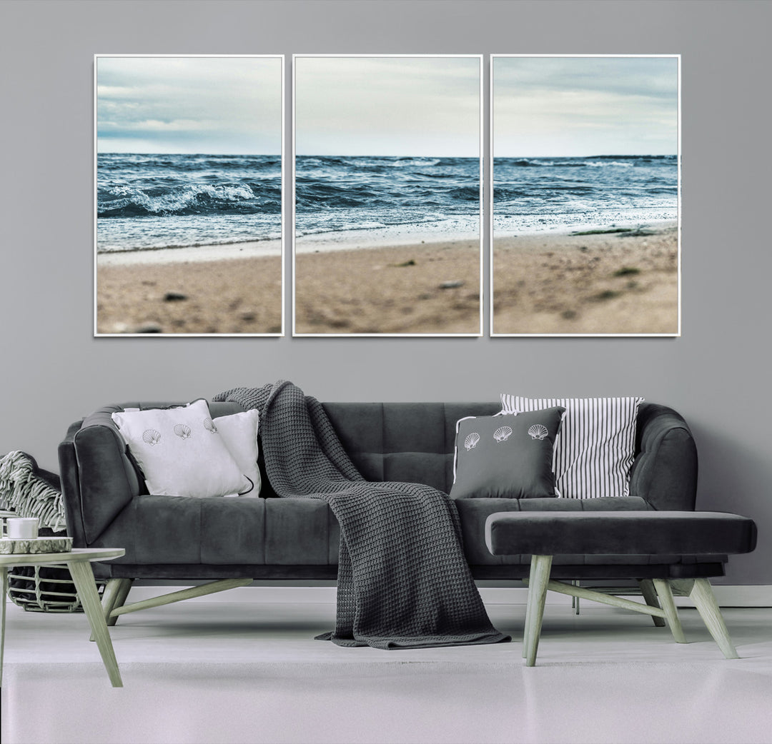 A moody ocean scene with gentle waves washing onto a sandy beach under a cloudy sky, creating a peaceful and coastal atmosphere.
