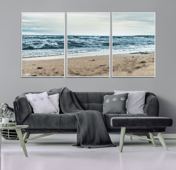 A moody ocean scene with gentle waves washing onto a sandy beach under a cloudy sky, creating a peaceful and coastal atmosphere.