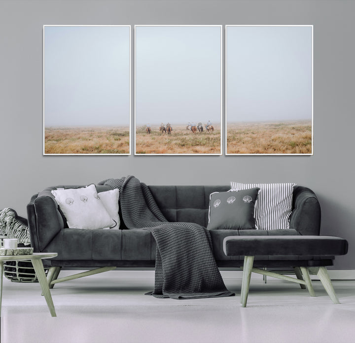 A group of horseback riders moving through a fog-shrouded field, evoking a calm Western scene with golden grasses and soft horizons.