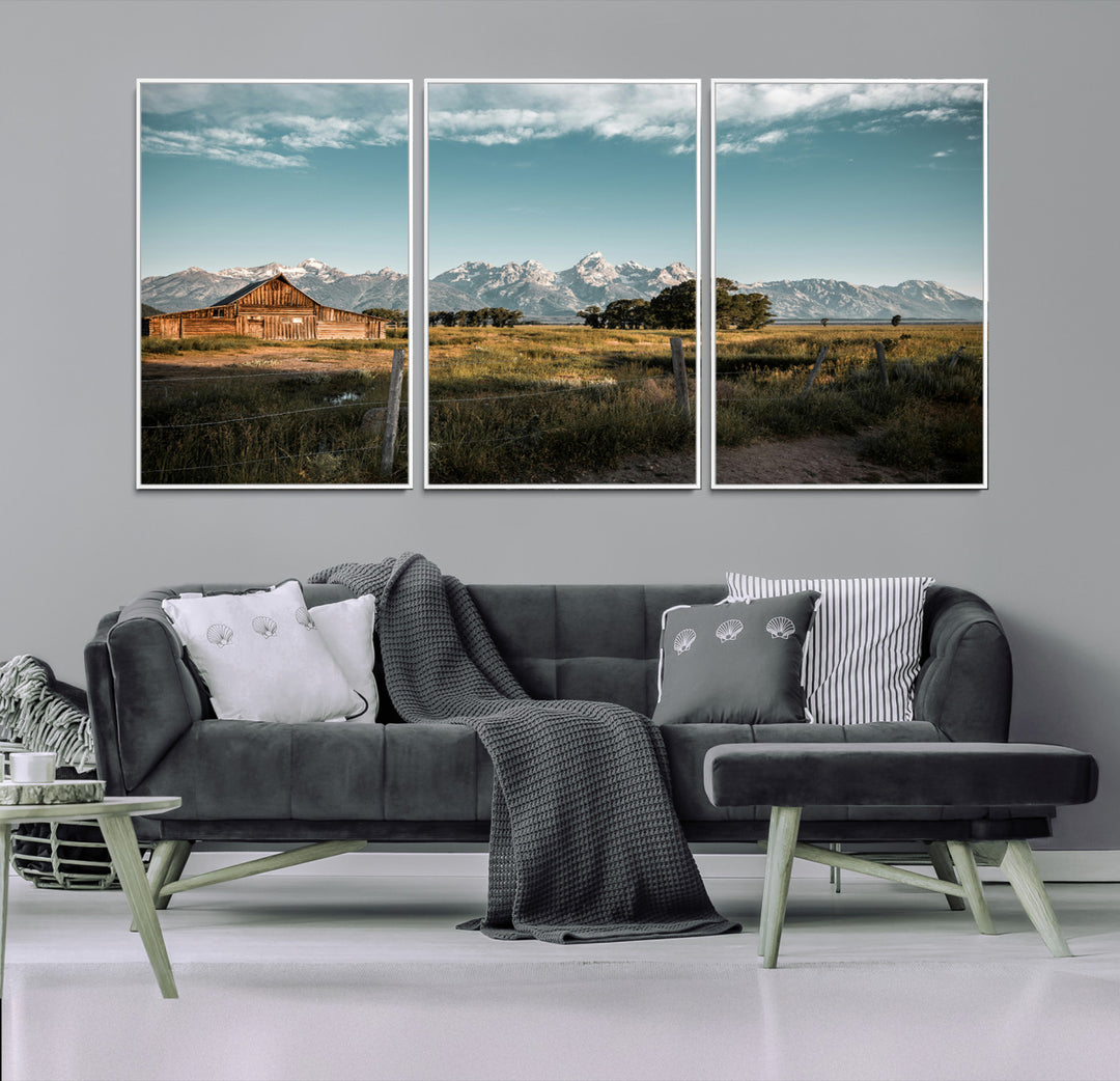 A rustic farmhouse with a wooden barn set against majestic mountain peaks under a soft blue sky, evoking peaceful countryside charm.