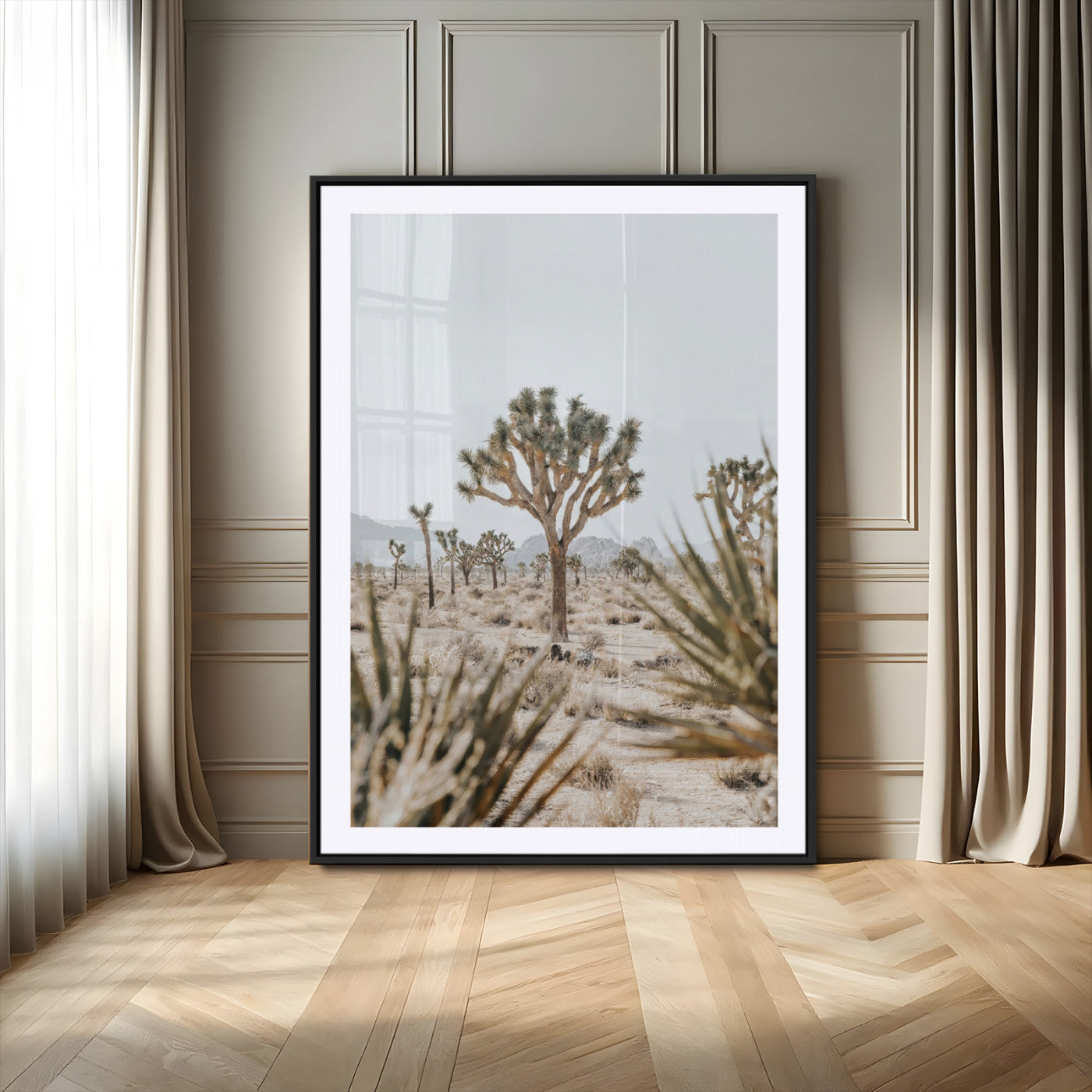 A wide desert landscape featuring multiple Joshua trees with spiky leaves and twisted branches, set against a pale sky and distant rocky hills. The foreground has blurred desert shrubs, emphasizing depth.