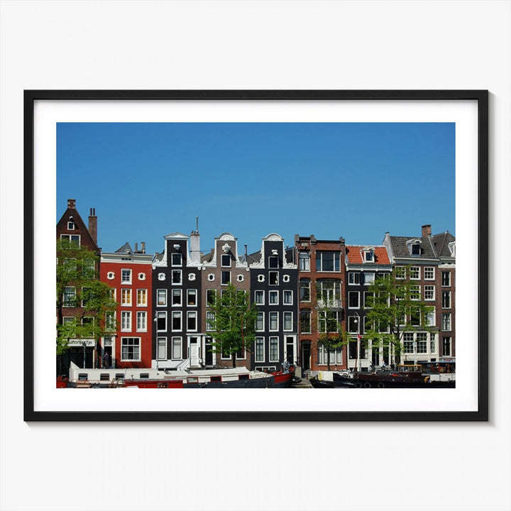 The Amsterdam City Wall Art Canvas Print showcases colorful traditional canal houses and boats set against a clear blue sky.