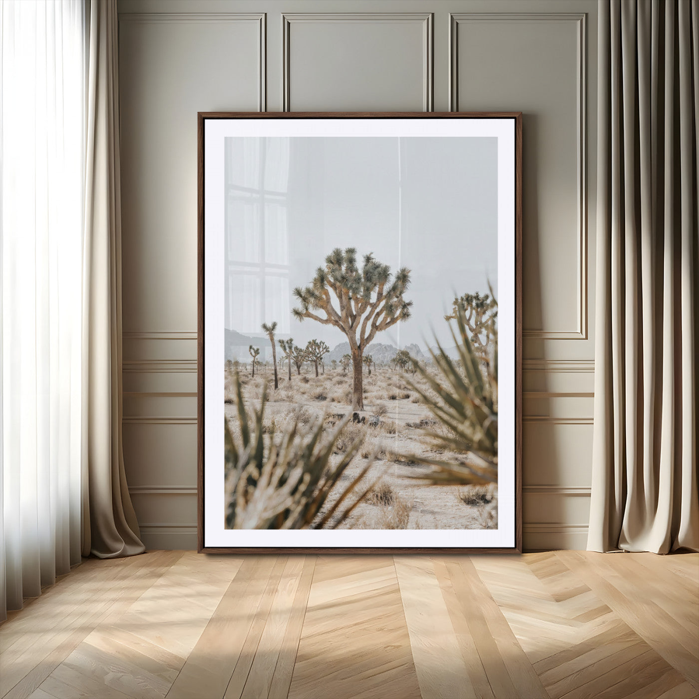 A wide desert landscape featuring multiple Joshua trees with spiky leaves and twisted branches, set against a pale sky and distant rocky hills. The foreground has blurred desert shrubs, emphasizing depth.