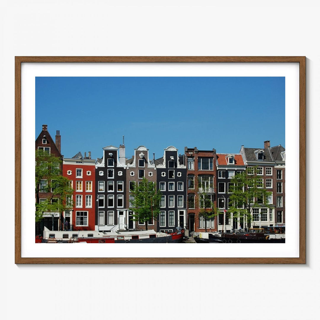 The Amsterdam City Wall Art Canvas Print showcases colorful traditional canal houses and boats set against a clear blue sky.