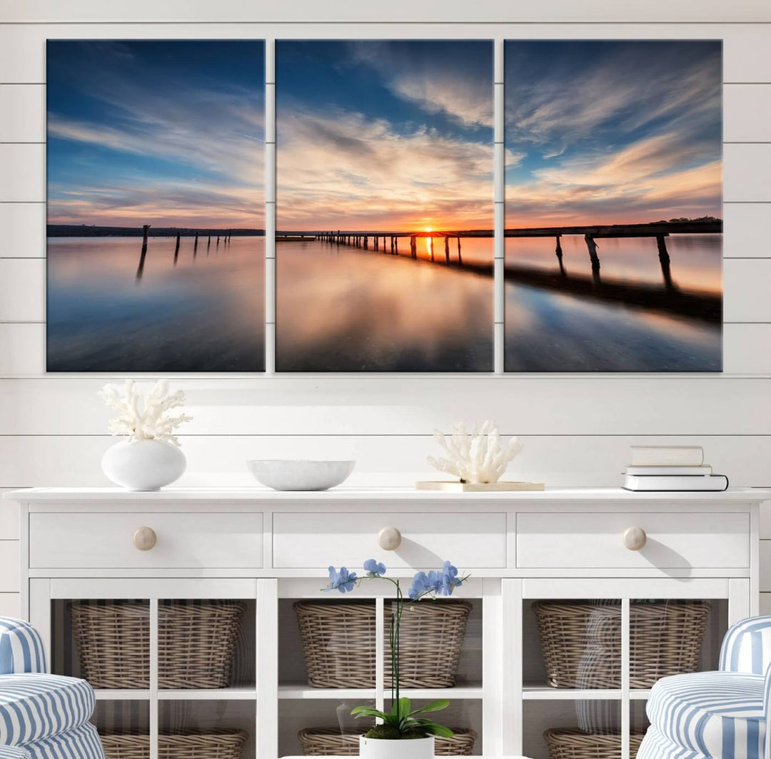 The Sunset Pier Canvas features a serene coastal landscape with vibrant hues under cloudy skies, ideal for modern decor.