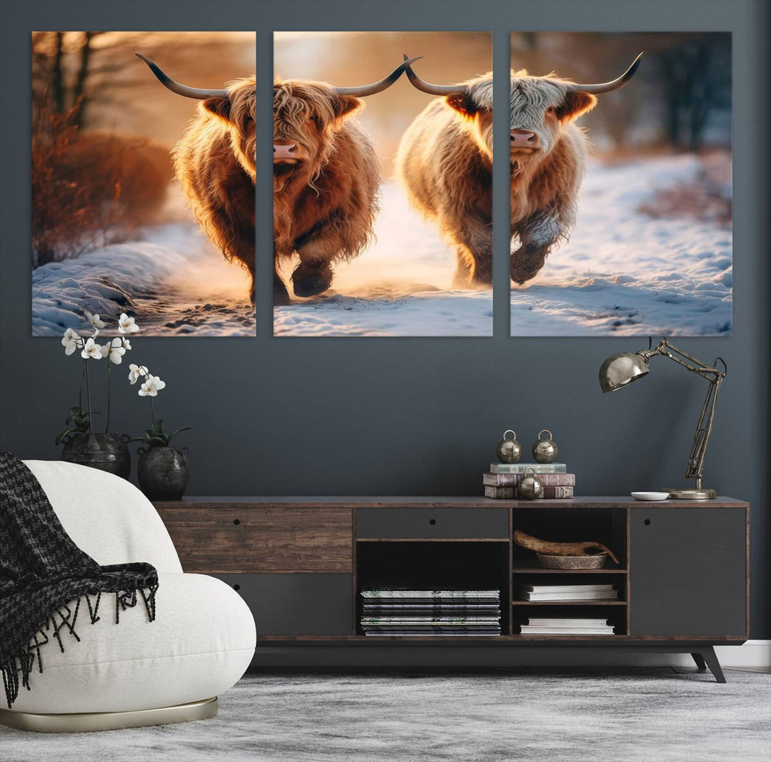 The wall art is a Scottish Highland Cow Horn canvas print featuring cows on a snowy path bathed in warm sunlight, serving as a rustic decor piece.