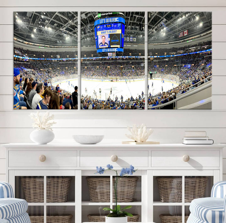 Wall art prints depicting the bustling scenes of the St. Louis Blues being cheered on by a full house at the Enterprise Center, beneath a large scoreboard.