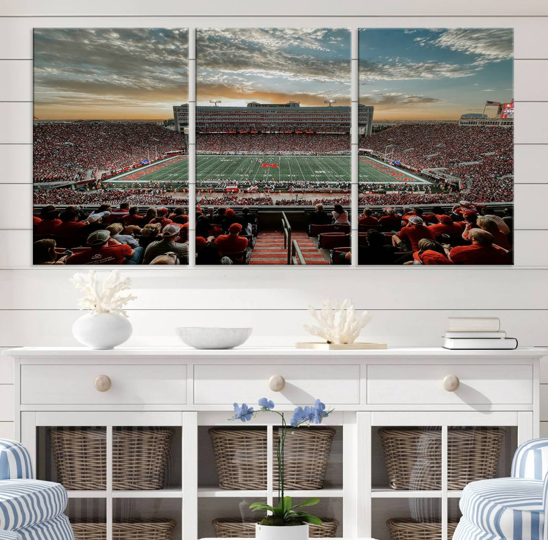 The living room features a stunning triptych of Lincoln Memorial Stadium wall art canvas print, celebrating the University of Nebraska Cornhuskers football team. This piece serves as captivating wall art, showcasing a gallery-quality finish.