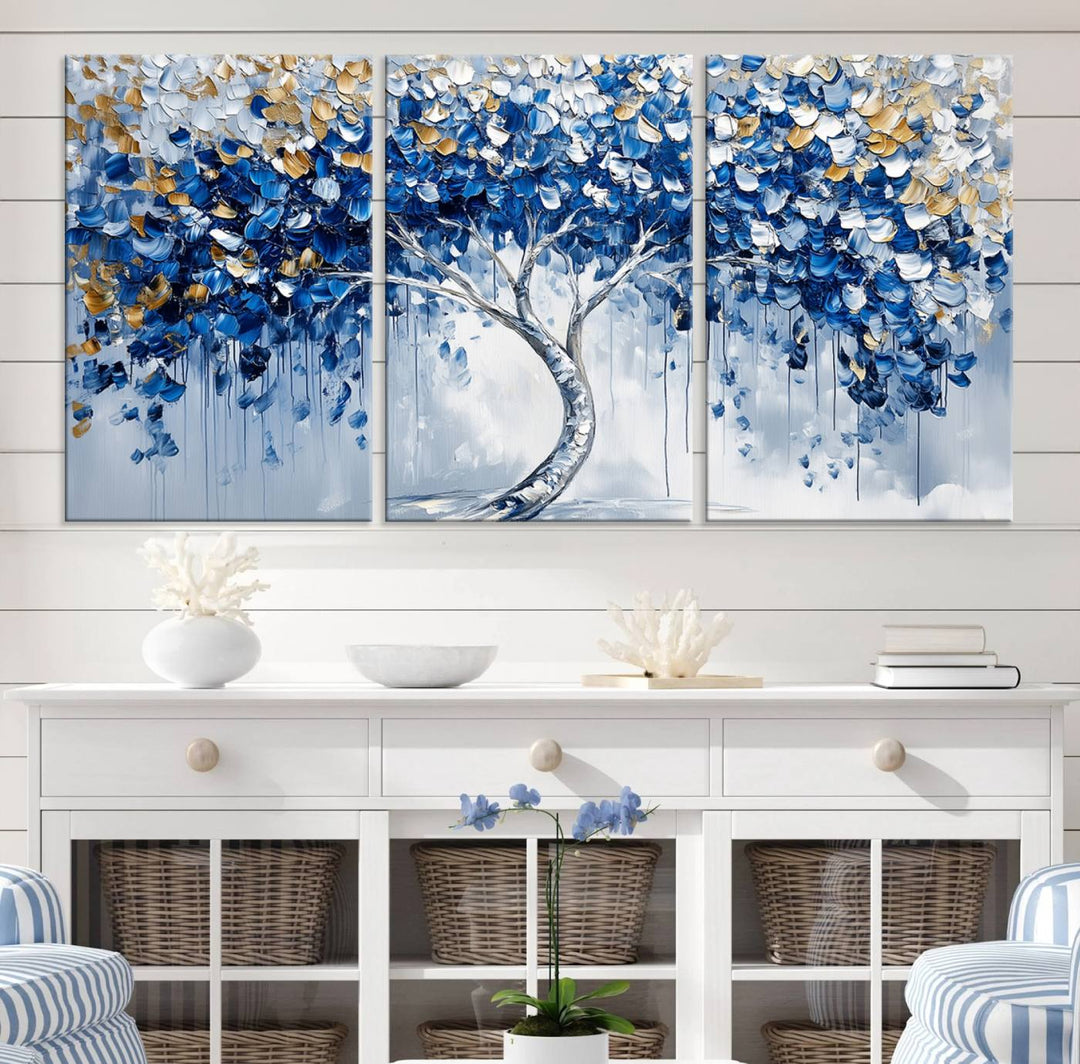 The Blue and Gold Abstract Tree Wall Art showcases a swirl trunk and features blue, silver, and gold leaves on a framed canvas print.