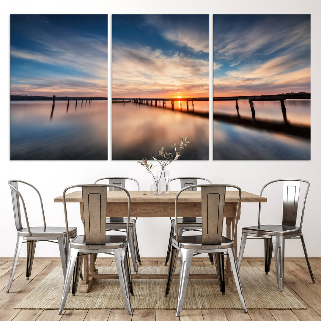 The Sunset Pier Canvas features a serene coastal landscape with vibrant hues under cloudy skies, ideal for modern decor.