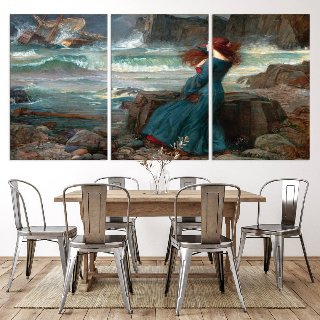 The Miranda by the Shore Wall Art Canvas Print depicts a woman in a blue dress standing by the sea, watching a shipwreck.