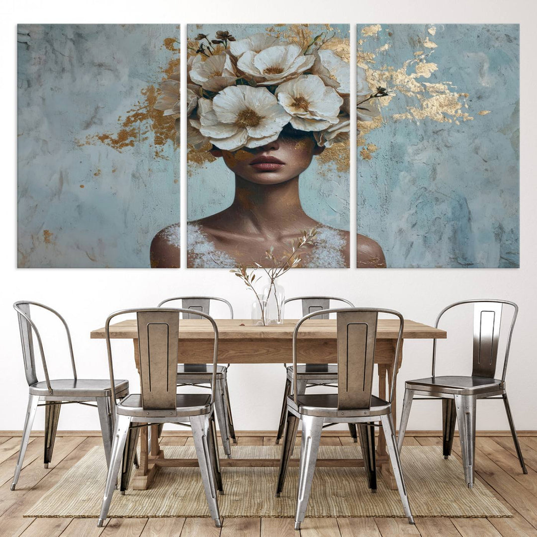 The Golden Petal Silhouette Woman Wall Art Canvas Print, a large 3-panel canvas with a textured gold floral design, serves as a luxurious centerpiece in modern glam settings. The artwork depicts a woman with flowers over her eyes against a textured background and hangs elegantly.