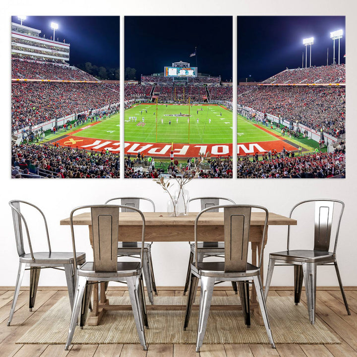 A NC State Wolfpack Football Team print of Carter-Finley Stadium at night features WOLFPACK illuminated brightly in the end zone grass.