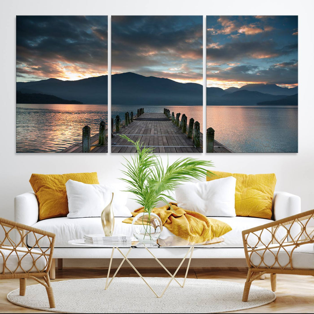 The Mountain Lake Wood Pier Canvas Wall Art depicts a serene lake and mountains, enhancing the beauty of any space.