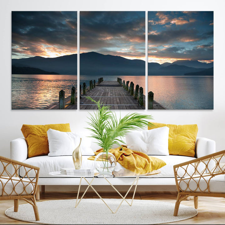 The Mountain Lake Wood Pier Canvas Wall Art depicts a serene lake and mountains, enhancing the beauty of any space.