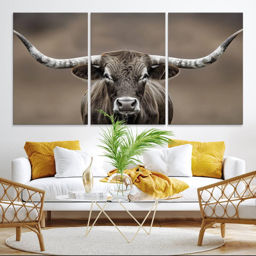 A close-up of a longhorn bull facing forward is featured in the Framed Texas Test-1, set against a blurred brown background.