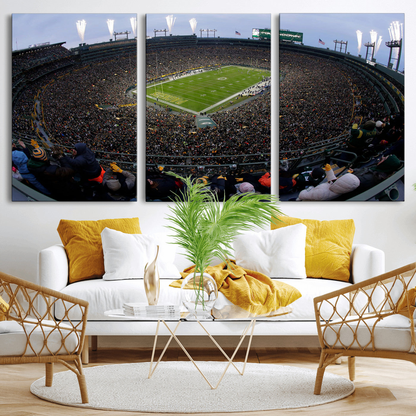 Wide fisheye view of a packed Lambeau Field stadium during an American football game. The crowd fills the stands, and fireworks are going off above the stadium lights. The scoreboard displays "Touchdown," and the field has "Packers" painted in the end zon