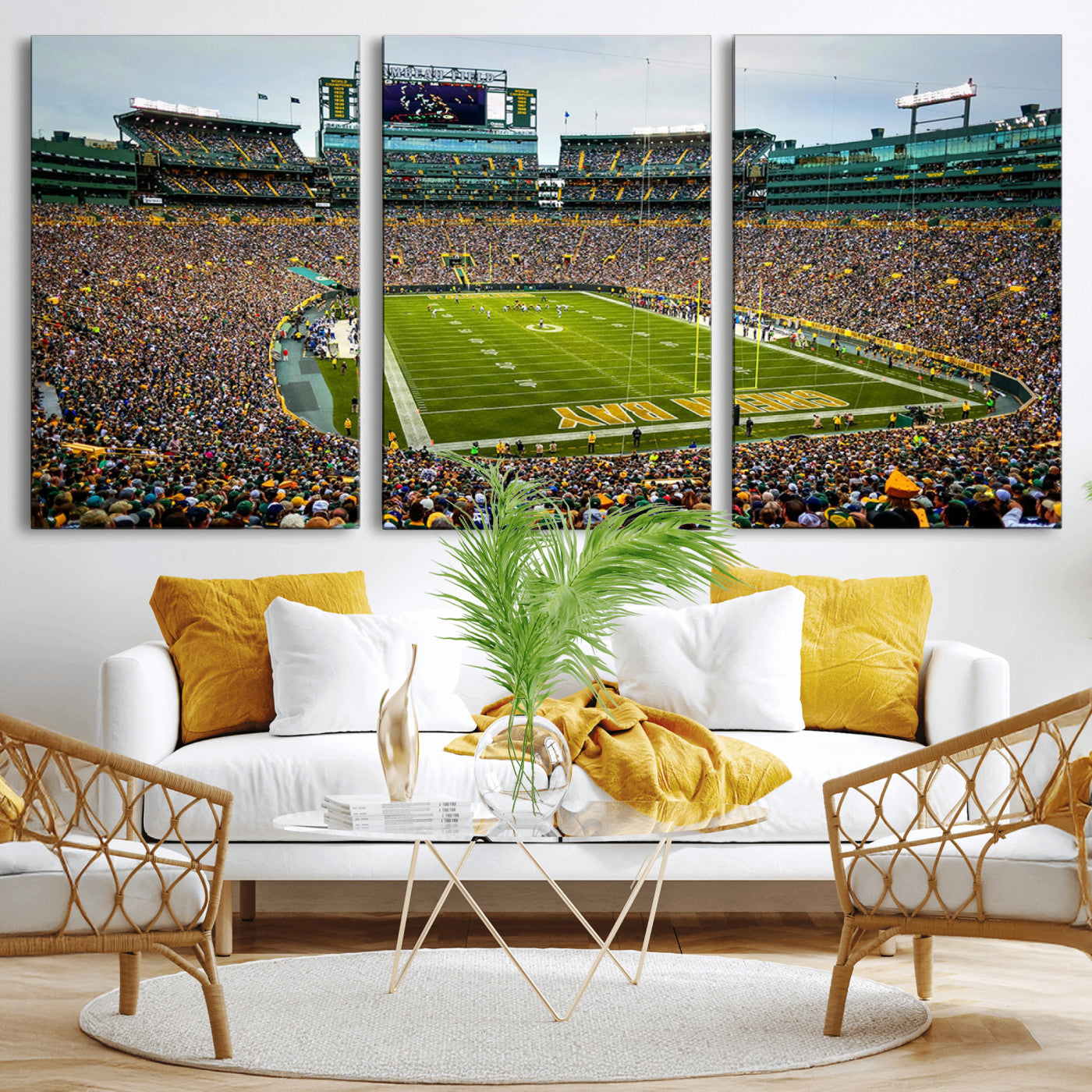 Packed football stadium with thousands of fans watching an American football game on a well-maintained field. The scoreboard displays "Lambeau Field," and players are lined up on the field. The stadium is surrounded by multiple tiers of seating filled wit