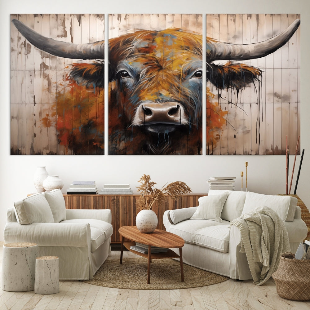 The "Abstract Bull Highland Cow Canvas Wall Art Print," displayed as a three-panel piece, adds vibrant rustic charm to a living room. Its depiction of a large, horned bull beautifully complements the elegance of modern farmhouse decor.