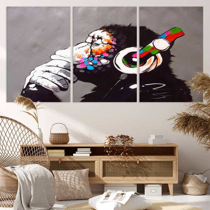 A vibrant triptych, the "DJ Monkey Listening to Music" wall art print, features a Banksy-inspired large canvas adorned with colorful modern pop art. This striking piece elegantly enhances the room with its dynamic and lively depiction.