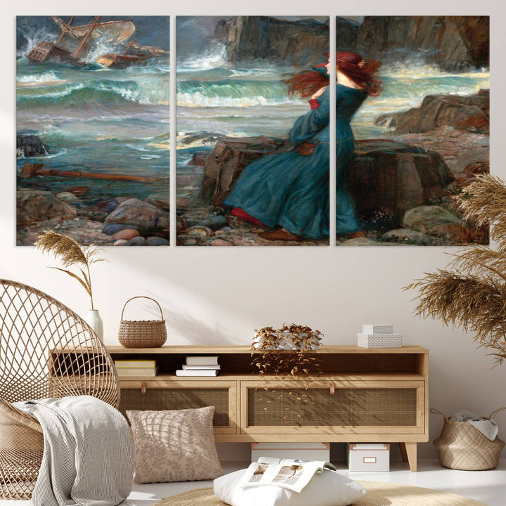 The Miranda by the Shore Wall Art Canvas Print depicts a woman in a blue dress standing by the sea, watching a shipwreck.