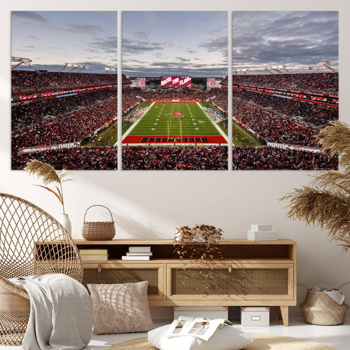 The wall art captures a stunning scene of Raymond James Stadium bathed in the warm hues of sunset. The sky, filled with clouds, provides a dramatic contrast to the vibrant lighting on the field, encapsulating the dynamic energy of a football game.