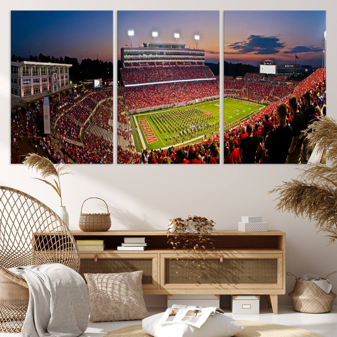 A print of a bustling Carter-Finley Stadium at dusk, featuring fans and a band, captures the essence of NC State Wolfpack football.