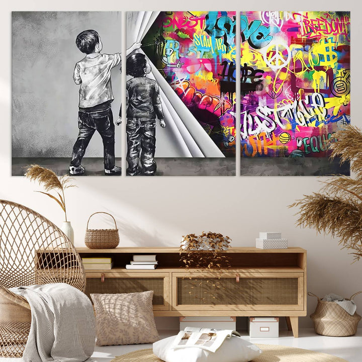 The Banksy Print - Street Art Canvas features a vibrant and bold image of two children lifting a curtain to reveal colorful graffiti. It's ready to hang, adding an urban modern decor vibe.