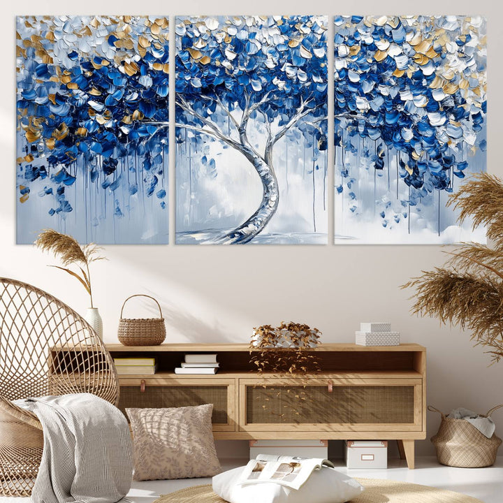 The Blue and Gold Abstract Tree Wall Art showcases a swirl trunk and features blue, silver, and gold leaves on a framed canvas print.