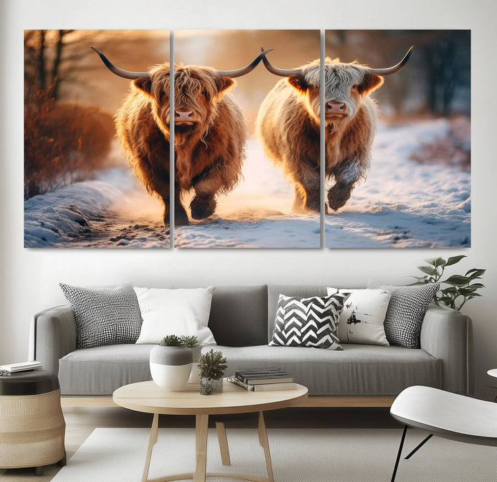 The wall art is a Scottish Highland Cow Horn canvas print featuring cows on a snowy path bathed in warm sunlight, serving as a rustic decor piece.