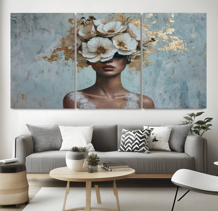 The Golden Petal Silhouette Woman Wall Art Canvas Print, a large 3-panel canvas with a textured gold floral design, serves as a luxurious centerpiece in modern glam settings. The artwork depicts a woman with flowers over her eyes against a textured background and hangs elegantly.