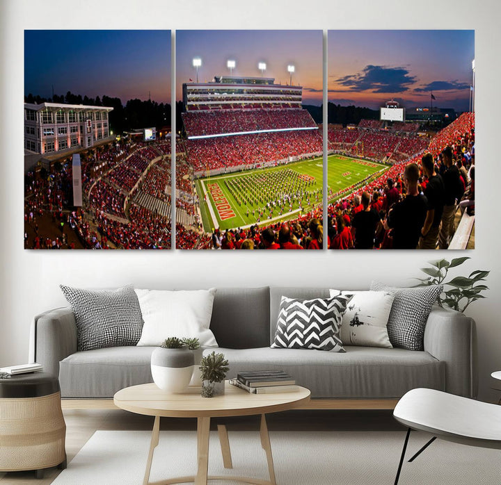 A print of a bustling Carter-Finley Stadium at dusk, featuring fans and a band, captures the essence of NC State Wolfpack football.