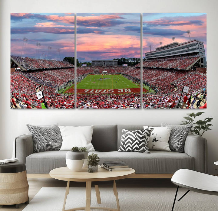 The wall art captures an NC State Wolfpack game under a vibrant sunset on triple canvas.